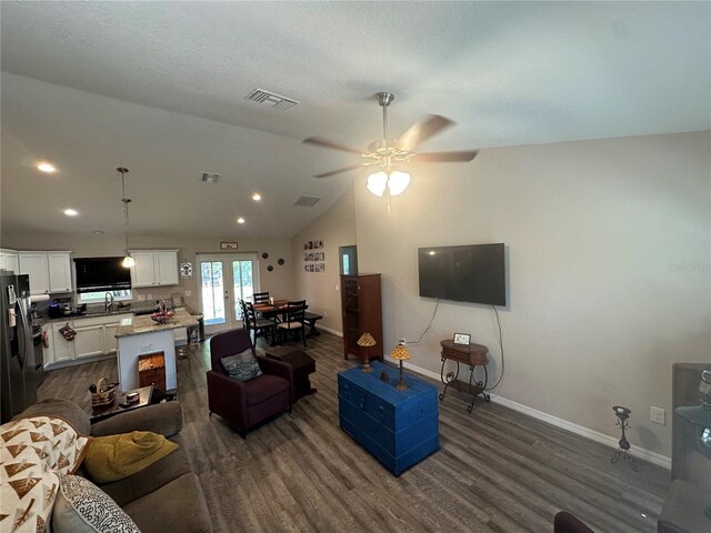 living area featuring ceiling fan, visible vents, baseboards, and dark wood-type flooring