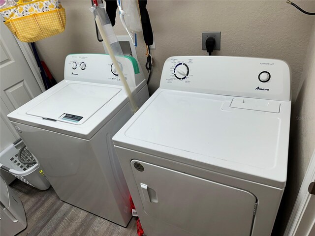 clothes washing area with laundry area, independent washer and dryer, and wood finished floors