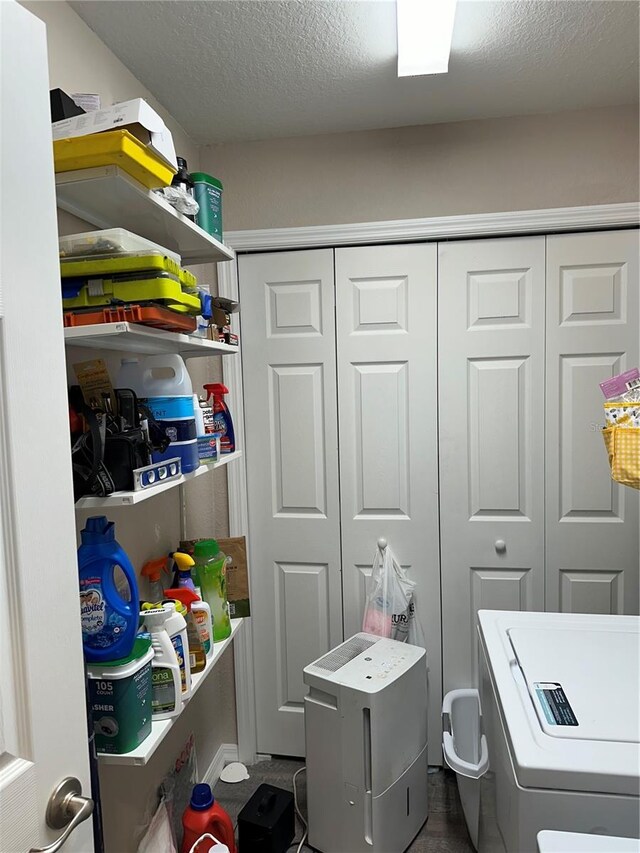 laundry room with a textured ceiling, laundry area, and washer / clothes dryer