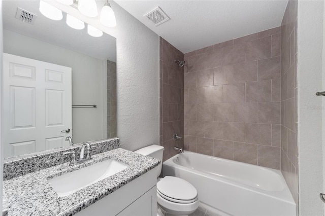 bathroom with a textured wall, toilet, shower / bathtub combination, and vanity