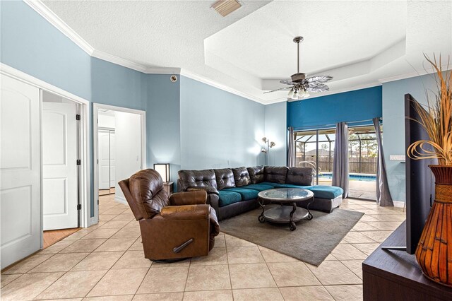 6045 SE 99th Pl, Belleview, FL 34420 - living room with a raised ceiling, a textured ceiling, a ceiling fan, light tile patterned floors, and visible vents