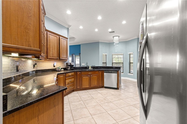 6045 SE 99th Pl, Belleview, FL 34420 - kitchen with crown molding, a peninsula, brown cabinets, appliances with stainless steel finishes, and light tile patterned floors