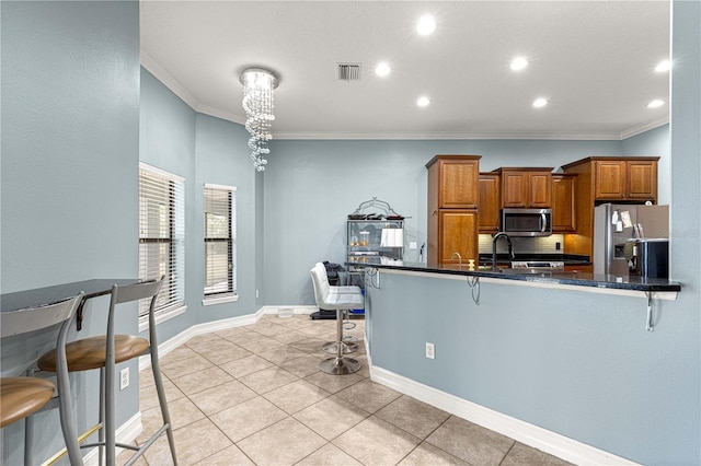 6045 SE 99th Pl, Belleview, FL 34420 - kitchen with crown molding, a kitchen breakfast bar, appliances with stainless steel finishes, and brown cabinetry