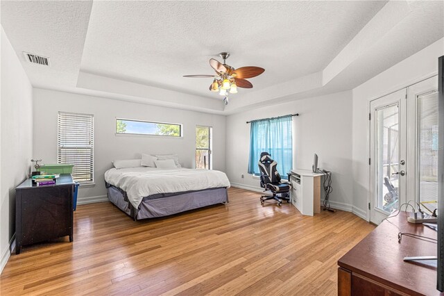6045 SE 99th Pl, Belleview, FL 34420 - bedroom with a raised ceiling, light wood-type flooring, a textured ceiling, and visible vents