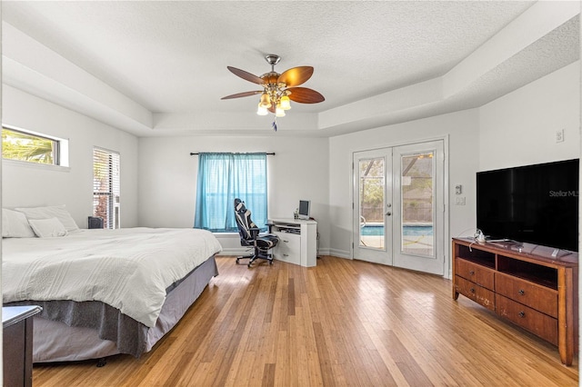 6045 SE 99th Pl, Belleview, FL 34420 - bedroom with multiple windows, a raised ceiling, access to exterior, light wood-style flooring, and french doors
