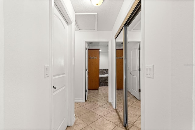 6045 SE 99th Pl, Belleview, FL 34420 - hallway with a textured ceiling, light tile patterned floors, and attic access