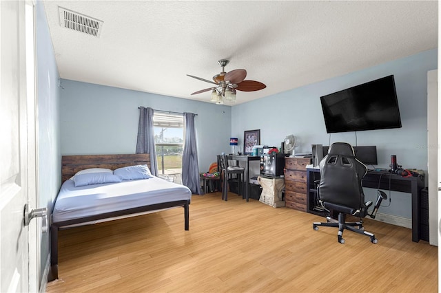 6045 SE 99th Pl, Belleview, FL 34420 - bedroom with visible vents, a ceiling fan, a textured ceiling, and wood finished floors