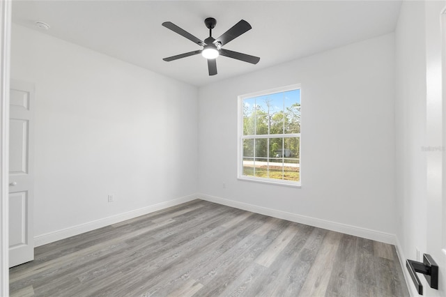 empty room featuring a ceiling fan, baseboards, and wood finished floors