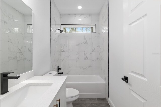 bathroom featuring vanity, shower / bath combination, toilet, and wood finished floors