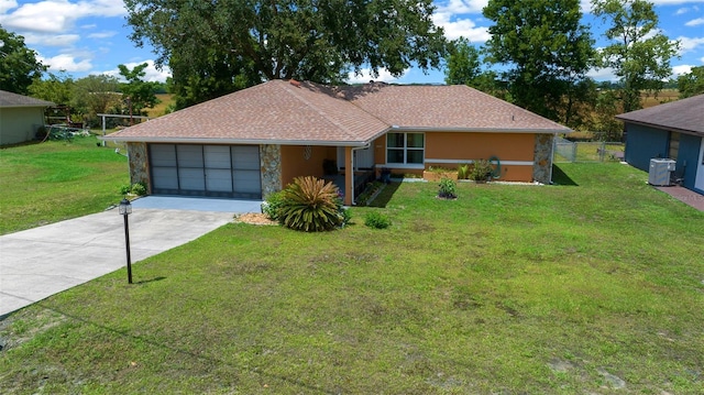 single story home with an attached garage, fence, driveway, and a front lawn