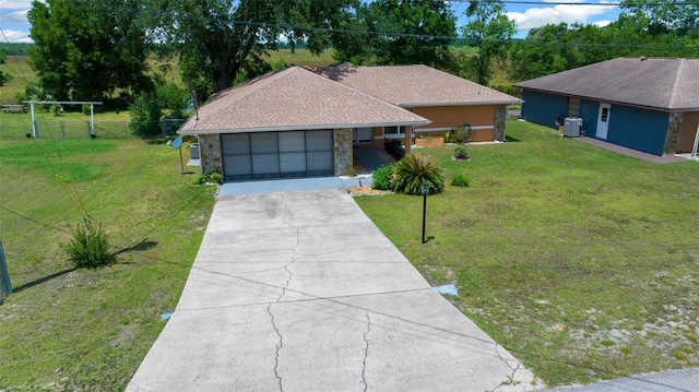 prairie-style house with an attached garage, a front lawn, fence, and concrete driveway