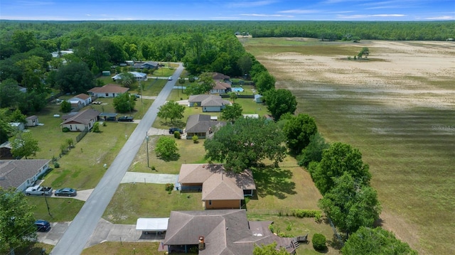 drone / aerial view featuring a residential view and a wooded view