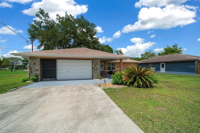 ranch-style house with a garage, concrete driveway, a front yard, and stone siding