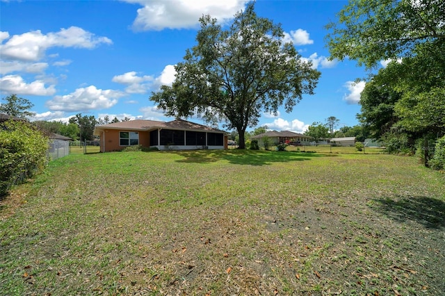 view of yard featuring fence and a sunroom