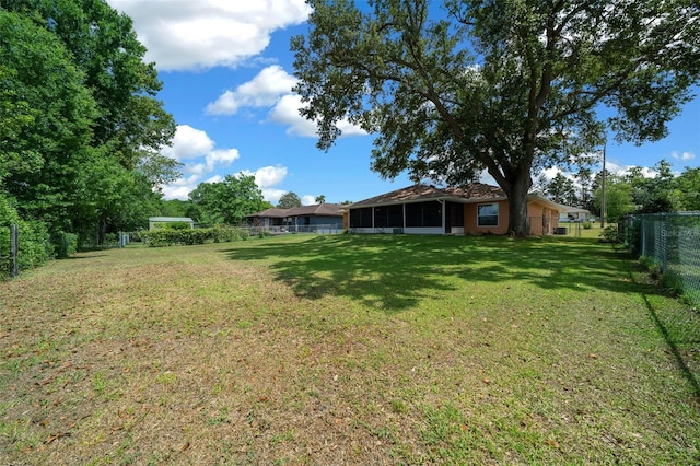 view of yard with a fenced backyard and a sunroom