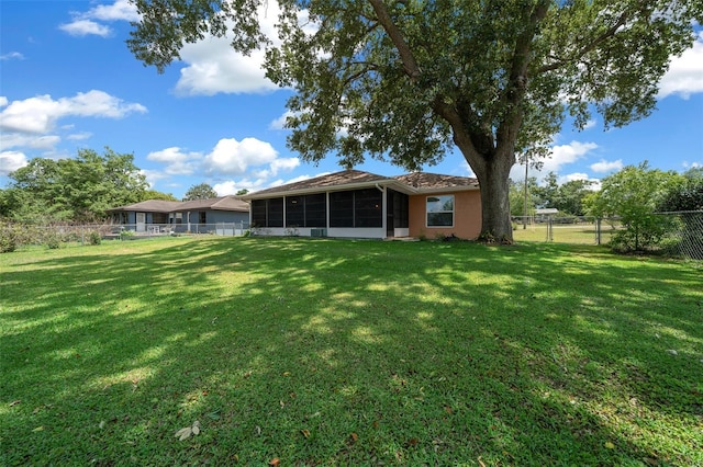 view of yard featuring a fenced backyard and a sunroom