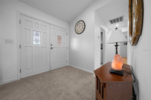foyer entrance featuring baseboards, carpet, and visible vents