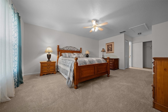 carpeted bedroom with a ceiling fan, a textured ceiling, visible vents, baseboards, and a closet