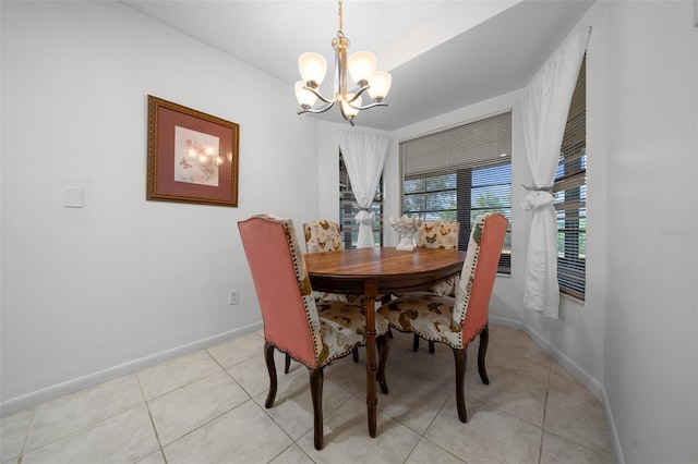 dining space featuring baseboards, an inviting chandelier, and light tile patterned floors
