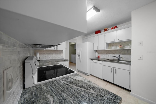kitchen with a sink, white appliances, white cabinetry, light tile patterned floors, and tasteful backsplash