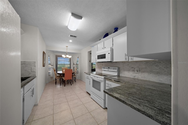 kitchen featuring dark countertops, white appliances, white cabinetry, a chandelier, and backsplash