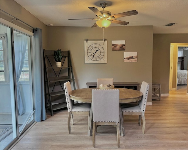 dining space featuring baseboards, a ceiling fan, light wood finished floors, and visible vents