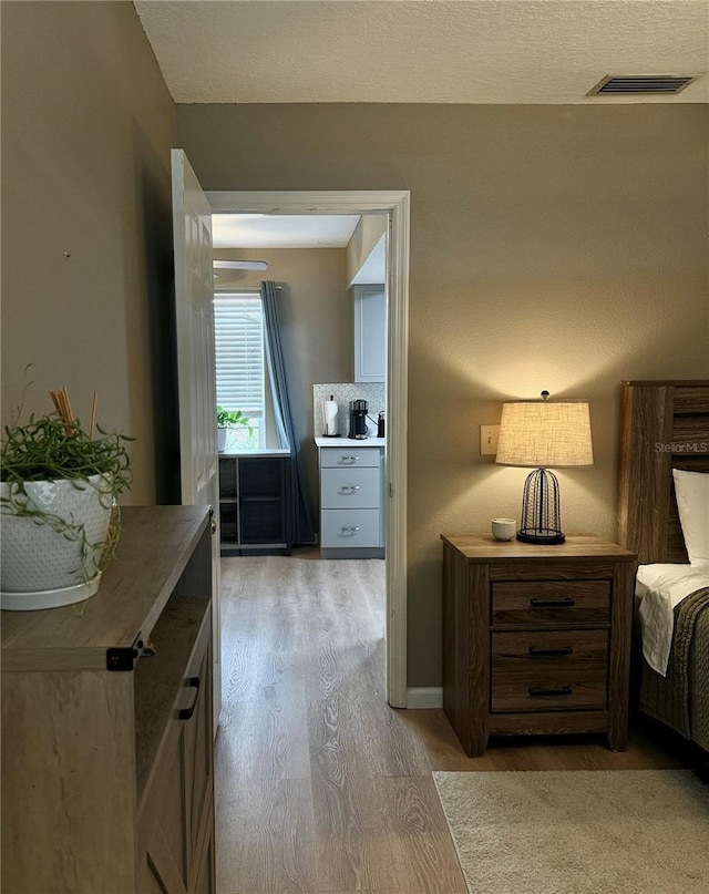 bedroom featuring light wood-type flooring and visible vents