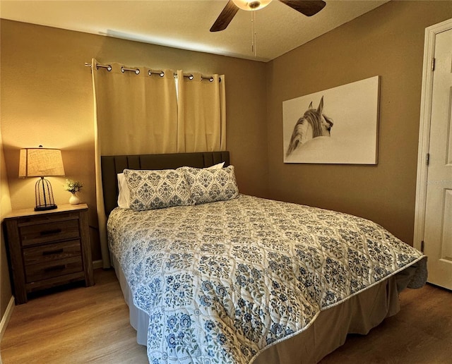 bedroom with baseboards, ceiling fan, and wood finished floors