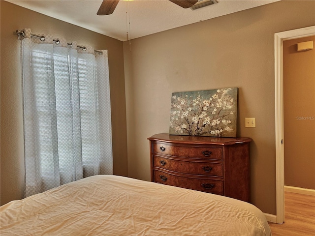 bedroom featuring baseboards, ceiling fan, and wood finished floors