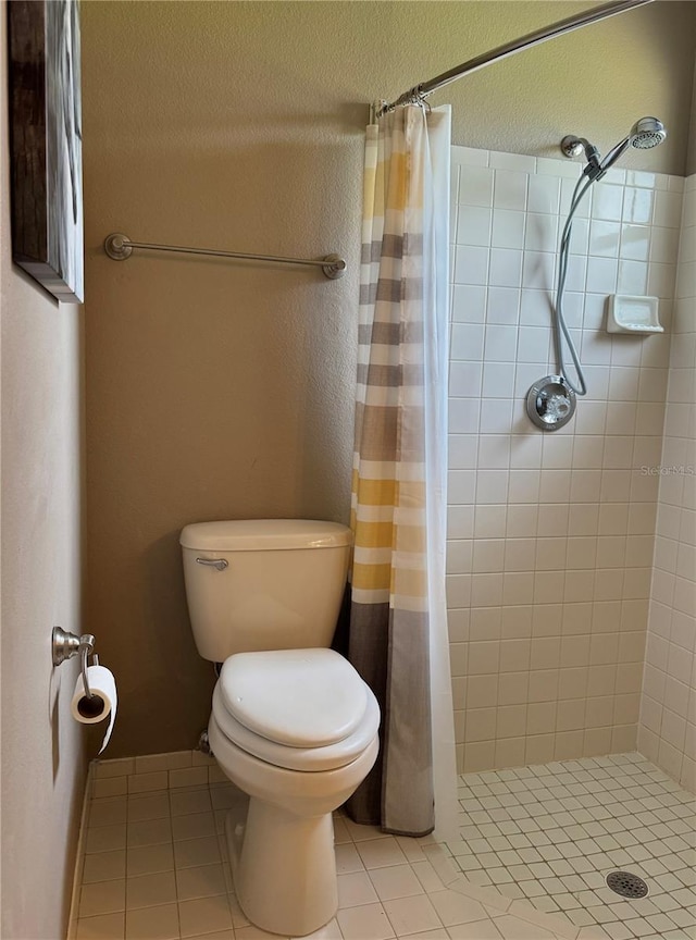 bathroom with tile patterned floors, a shower stall, and toilet