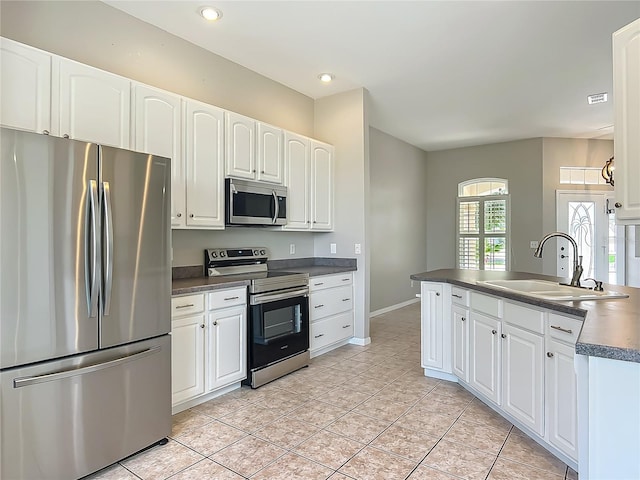 kitchen featuring visible vents, dark countertops, a sink, stainless steel appliances, and white cabinetry