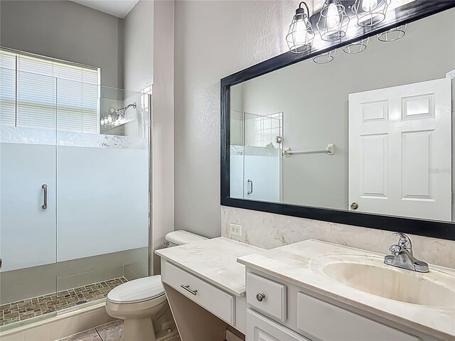 full bathroom featuring a stall shower, tile patterned floors, vanity, toilet, and a textured wall