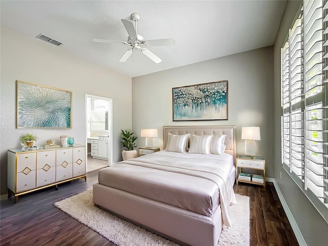 bedroom with visible vents, wood finished floors, baseboards, ensuite bathroom, and a ceiling fan