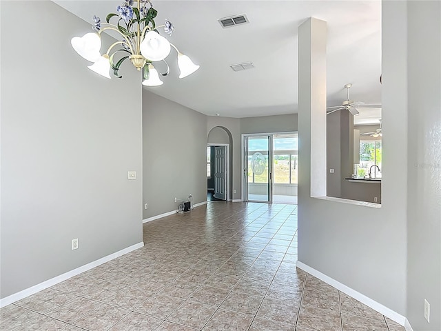 spare room featuring visible vents, baseboards, and ceiling fan with notable chandelier