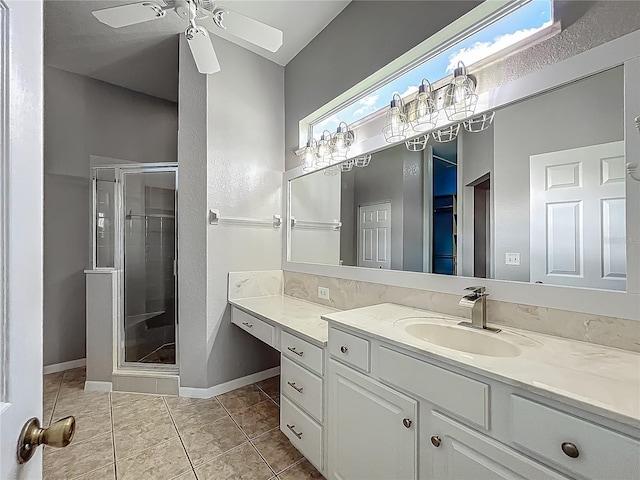 bathroom featuring ceiling fan, a stall shower, vanity, baseboards, and tile patterned floors