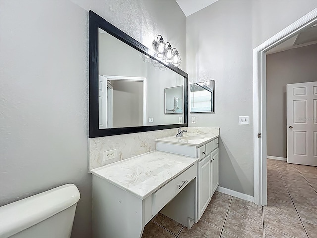 bathroom featuring tile patterned flooring, baseboards, toilet, and vanity