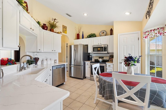 12147 SE 173rd Pl, Summerfield, FL 34491 - kitchen with visible vents, appliances with stainless steel finishes, arched walkways, a sink, and white cabinetry