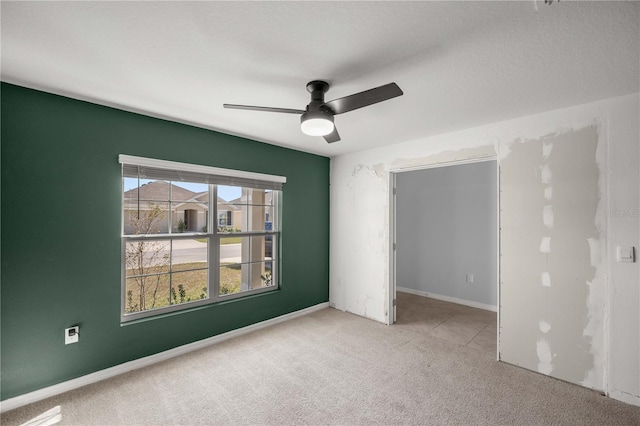 carpeted spare room featuring a ceiling fan
