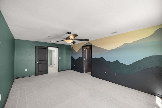 carpeted spare room featuring baseboards, a ceiling fan, and visible vents