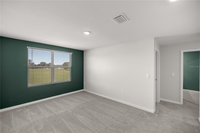 empty room featuring baseboards, visible vents, and carpet