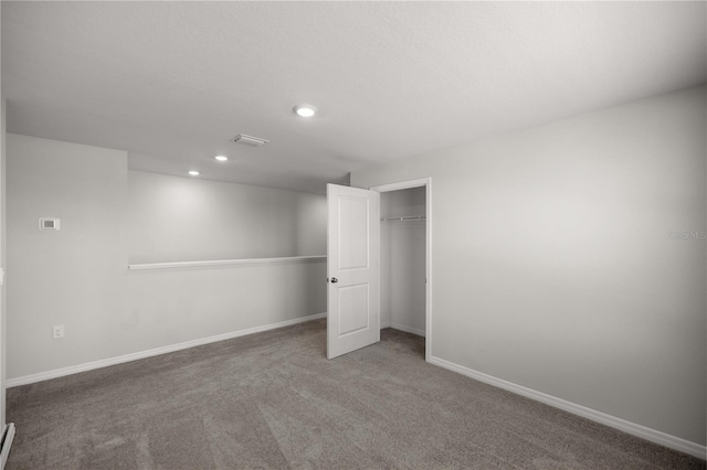 unfurnished bedroom featuring carpet, recessed lighting, baseboards, visible vents, and a closet