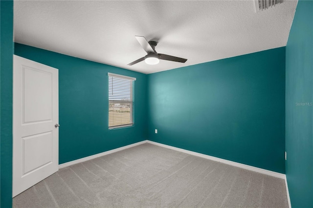 unfurnished room featuring a ceiling fan, a textured ceiling, visible vents, baseboards, and carpet