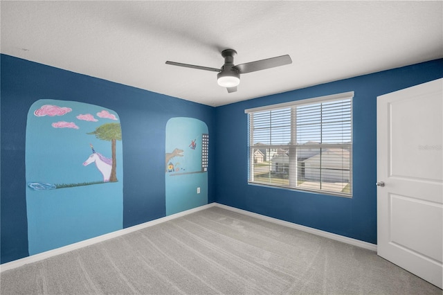 empty room with carpet floors, baseboards, and ceiling fan