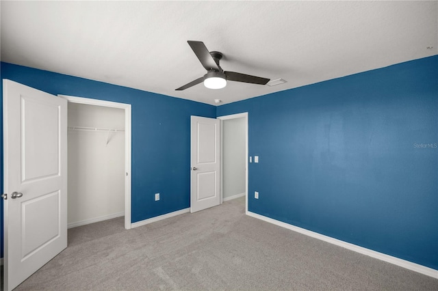 unfurnished bedroom featuring baseboards, ceiling fan, carpet, and a closet