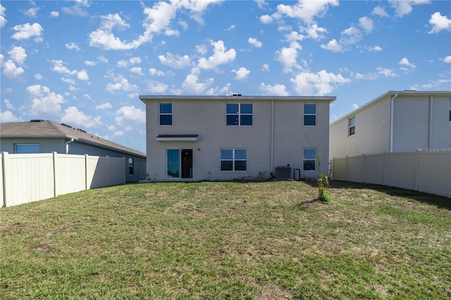 back of property with fence, central air condition unit, stucco siding, and a yard