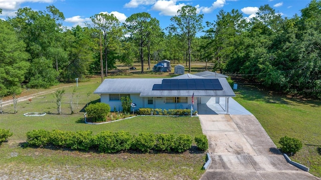 23737 NW Mallard Ave, Dunnellon, FL 34431 - view of front of property featuring driveway, solar panels, and a front lawn