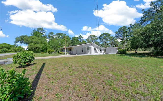 23737 NW Mallard Ave, Dunnellon, FL 34431 - back of house featuring a lawn, driveway, and an attached carport