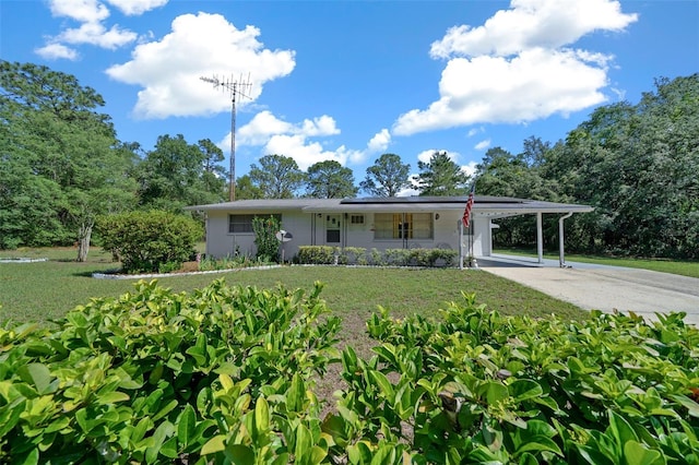 23737 NW Mallard Ave, Dunnellon, FL 34431 - view of front of property with concrete driveway, a front lawn, solar panels, and an attached carport