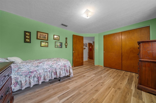 23737 NW Mallard Ave, Dunnellon, FL 34431 - bedroom with a textured ceiling, a closet, light wood-type flooring, and visible vents