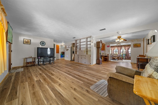 23737 NW Mallard Ave, Dunnellon, FL 34431 - living room with a ceiling fan, a textured ceiling, visible vents, baseboards, and light wood-style floors